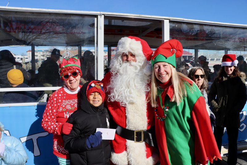 A crew of Lewes Chamber of Commerce volunteers greet Santa as he gets off the Cape Water Taxi boat. Shown are (l-r) Murt Foos, Ethan Foos and Robyn Dellemonache.